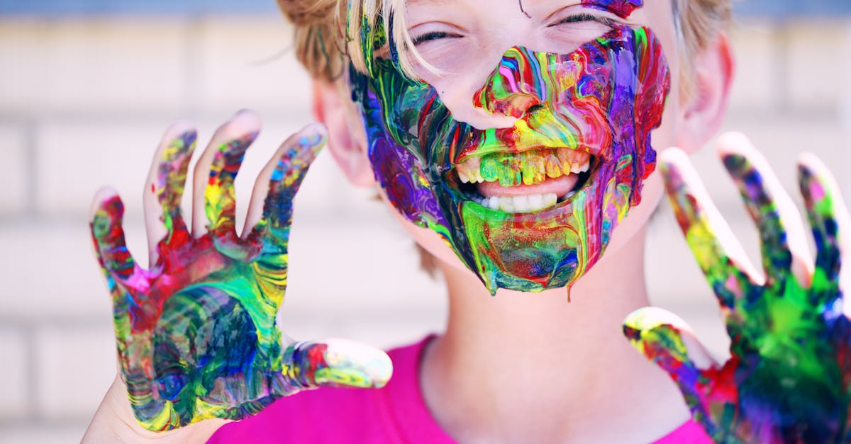 pexels-photo-1149022-1149022 A joyful child with vibrant face paint and hands, expressing happiness and creativity.